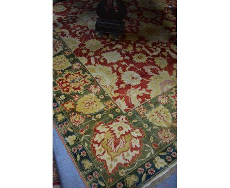 A handmade antiqued Agra carpet, the stylised floral design on soft coral and jade ground, 309 x 246 cm