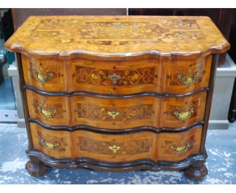 An 18th Century Dutch floral marquetry walnut commode of serpentine form, having three long graduated drawers on shaped feet,