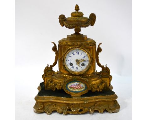 A 19th century gilt metal mantel clock with urn finial above enamel dial and Sevres style oval plaque painted with a cherub, 