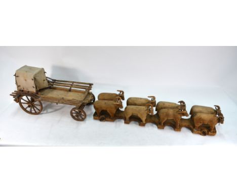 A 19th century South African carved wood large model 'Great Trek' ox-cart with canvas-covered wagon and eight oxen on truckle