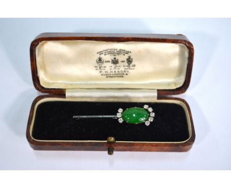 A green jade oval cabochon and diamond cluster style brooch on white metal bar, in fitted case supplied by P H Henry, Singapo