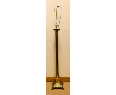 A brass Corinthian column standard lamp standing on paw feet 