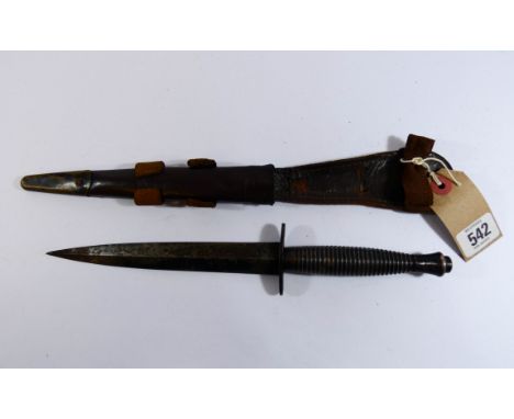 A commando fighting knife double edged blade approx 7" long complete with its brass mounted leather scabbard 