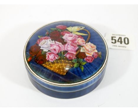 Circular enamel box and cover, decorated with a basket of flowers against a blue background with engine turned detail, unmark