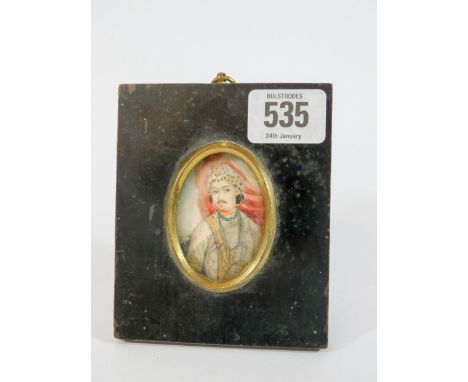 19th century oval Indian portrait miniature depicting a young Mughal prince, in black wooden easel style frame, frame measure