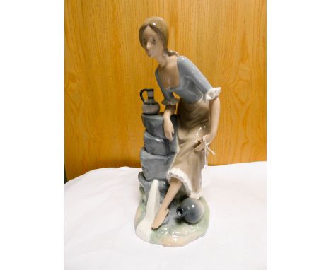 A Nao porcelain figure group of a girl washing her feet by a stream, height 35cms  