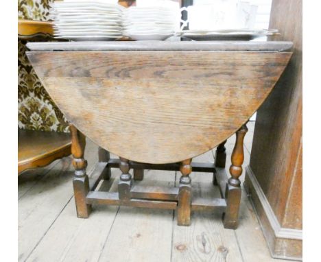 A small oval oak gate leg table on turned legs 2' wide 