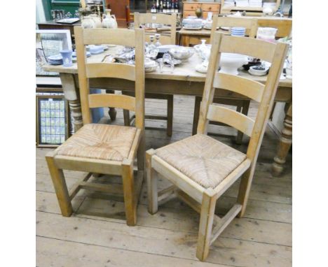A set of four heavy light oak ladder back dining room chairs with rush seats 