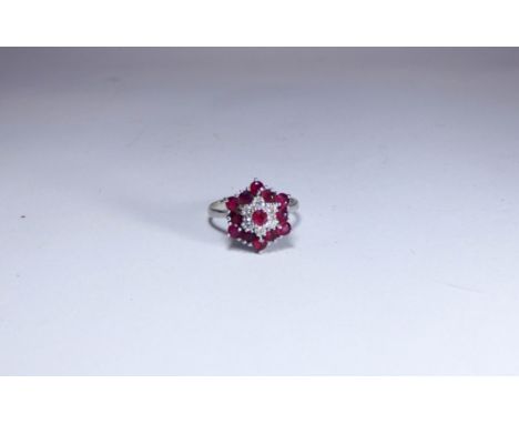 18ct white gold ruby and diamond cluster ring,  the cluster of hexagonal form, hallmarked. Ring size N/O