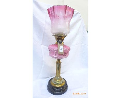 Victorian oil lamp with brass corinthian column on circular ebonised plinth,etched part cranberry glass shade and pink bowl w