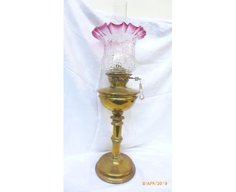 Brass oil lamp with decorative cranberry and clear glass shade