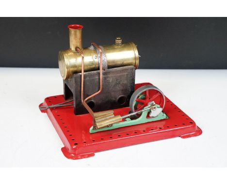 Steam Engine - Mamod stationary steam engine with red base, cylindrical engine with turning wheel, mechanism in working order