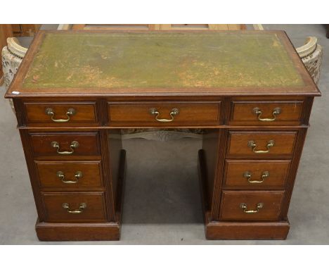 A small Edwardian mahogany twin pedestal desk with gilt tooled green leather top and nine drawers, 108 cm wide x 53 cm deep