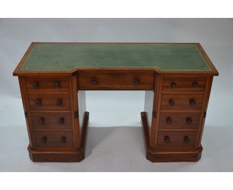 An antique pedestal desk with inset green leather top above a central short drawer, with four drawers to each pedestal, 122 c