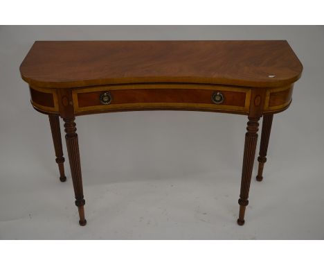 A mahogany crossbanded kidney shaped console table with frieze drawer, raised on turned and fluted supports, 115 cm wide