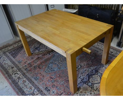 A modern light oak rectangular dining table on square supports, 140 x 90 cm