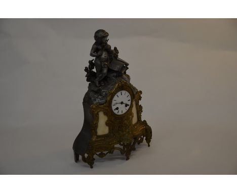 A French reproduction spelter mantle clock with music playing putti, twin train movement, 43 cm high