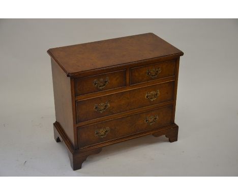 A small Georgian style walnut chest of two over two drawers, raised on bracket feet, 66 cm wide x 58 cm high x 36 cm deep