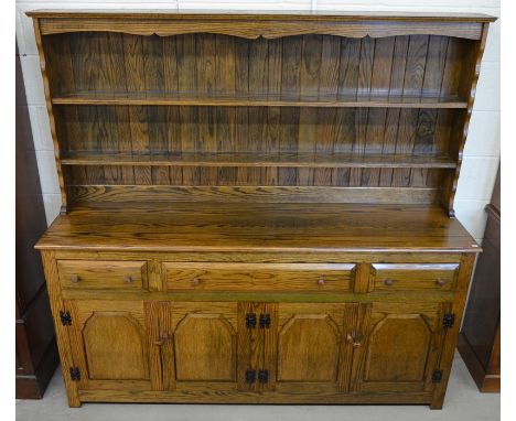 An elm dresser, the wide plate rack with two shelves on a base with three drawers over panelled cupboard doors, 186 cm wide x