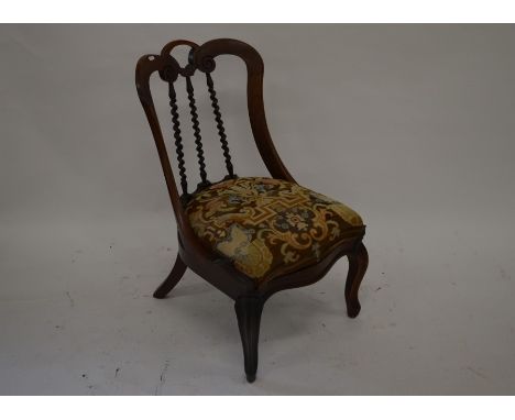 A Victorian rosewood nursing chair, splayed back with spiral turned spindles and tapestry seat cabriole front legs