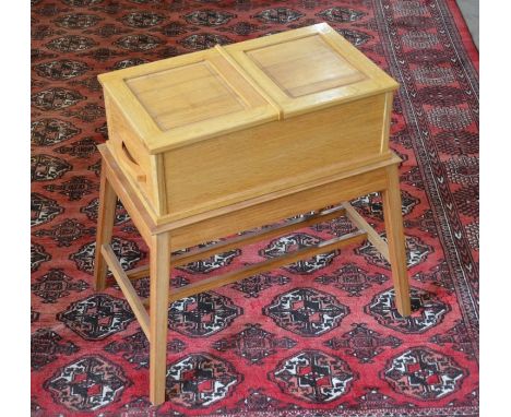 A small light oak sewing/work table with hinged top and side drawer raised on splayed supports with stretchers, 60 cm high