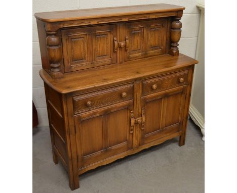 An Ercol dark elm low dresser with panelled cupboards and two drawers