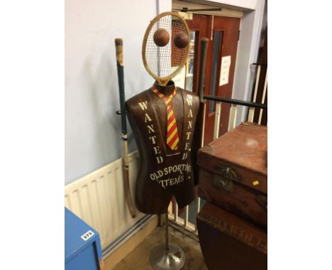 Sporting Advertising; a mannequin made from a tennis racket, cricket balls, cricket bat and hockey stick, printed with the wo