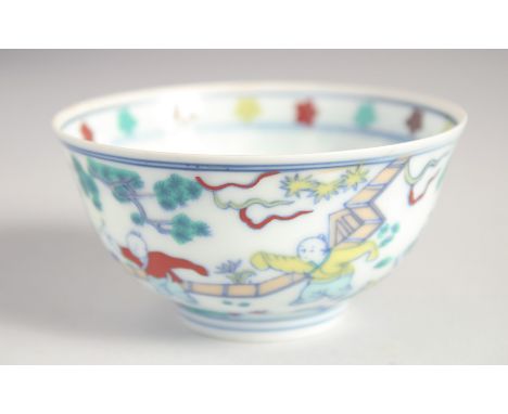 A CHINESE DOUCAI EGGSHELL PORCELAIN CUP painted with children playing, the base with six-character mark. 9cm diameter