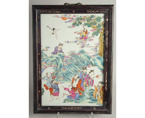 A CHINESE FAMILLE ROSE PORCELAIN PANEL encased within in a hardwood frame, the panel painted with immortals and farmers with 