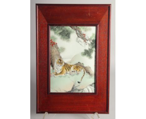 A GOOD CHINESE PORCELAIN PANEL in a wooden frame, painted with a reclining tiger, inscribed and with red mark, panel 25cm x 1