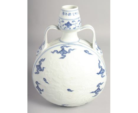 A CHINESE BLUE AND WHITE PORCELAIN TWIN HANDLED MOON FLASK with carved central dragon. 29.5cm high