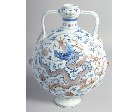 A CHINESE BLUE, WHITE, AND UNDERGLAZE RED TWIN HANDLED MOON FLASK painted with dragon and lotus, the base with four-character