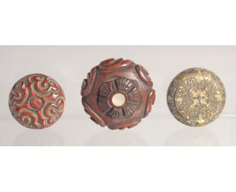THREE SMALL CIRCULAR BOXES; comprising a carved hardwood box with mother of pearl inset, a red lacquer box and a gilt metal b