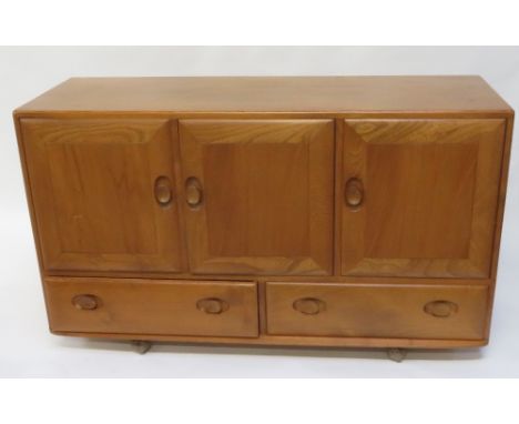 An Ercol elm and beech sideboard, with two door and one door cupboard sections, and two single long drawers, 76cm high, 130cm