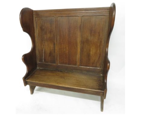 A 20th Century panel back dark oak settle, the left arm carved with a single mouse, by Robert “Mouseman” Thompson, 138cm high