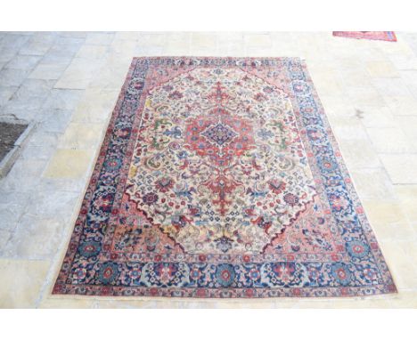 A Persian Tabriz carpet, with a central medallion on a cream ground, within a multi border, 392 x 283 cm