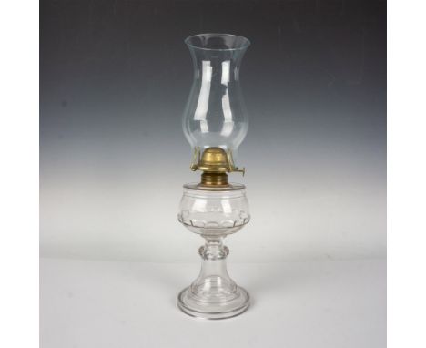 A clear oil lamp body decorated in an oval pattern. Includes an undercoated glass lamp shade. Dimensions: 4.75"W x 17.25"HCon