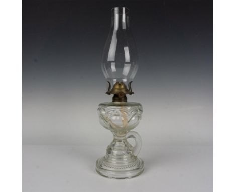 Tall oil lamp with pedestal base made of pattern glass and finished with finger handle. Includes Chimney glass marked Empire.