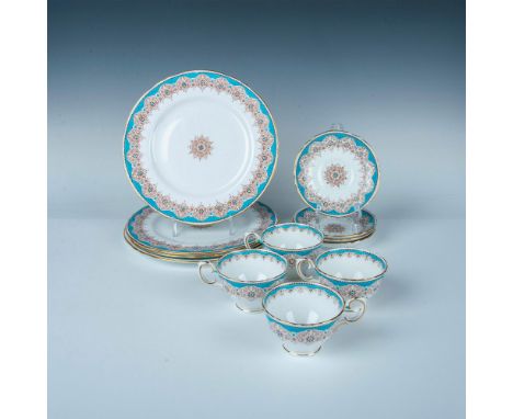 A set of 4 teacups, 4 saucers, and 4 plates, all in pristine white adorned with blue borders, gold-colored trims, and intrica