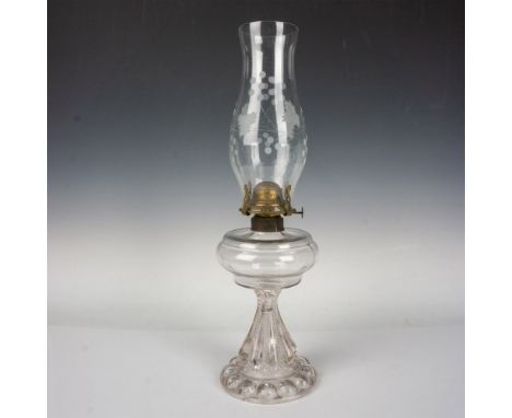 A clear glass press oil lamp body with a clear glass lamp shade adorned with etched grapevines. Dimensions: 5.5"W x 19.75"HCo