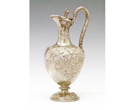 Victorian Scottish silver claret jug having allover embossed decoration, high rustic design handle, the hinged cover having a