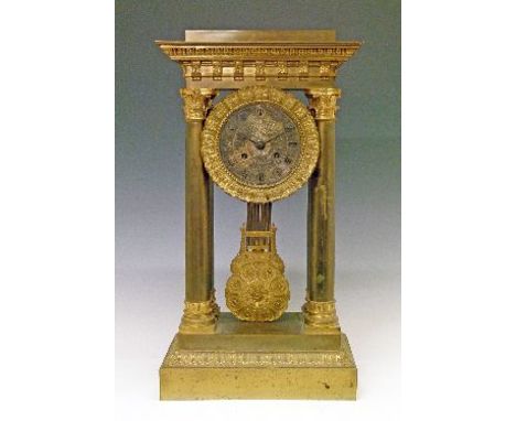 19th Century French brass and ormolu portico clock, the silvered dial with engraved decoration and Roman numerals, flanked by