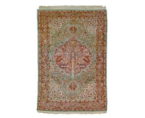 Persian silk rug having a central medallion decorated with a tree amongst tight-knit foliage on a jade green and off-white gr