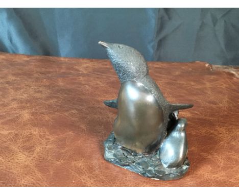 A delightful bronze-finished figurine by Richard Fisher featuring a penguin with two chicks, capturing the nurturing spirit o