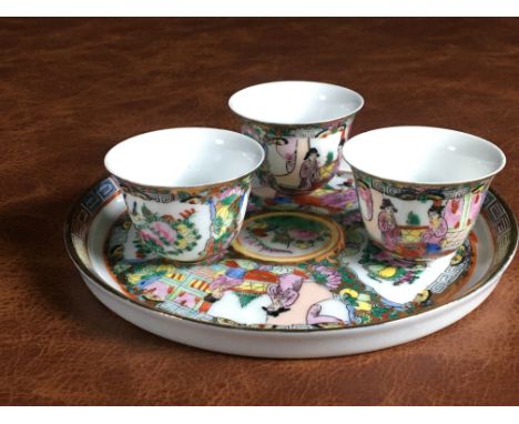 This elegant vintage Chinese sake set includes a beautifully decorated plate and three small cups, each adorned with traditio