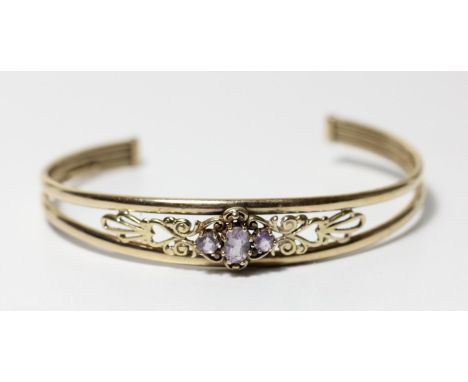 A 9ct gold and amethyst openwork bangle, 7.1gm 