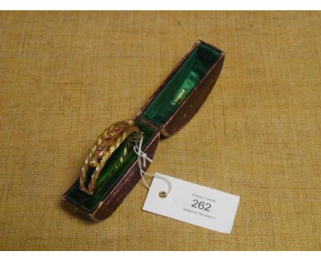 A late Victorian diamond and ruby set 9ct gold bangle, the stones plaque set within engraved twisted bands, with safety chain