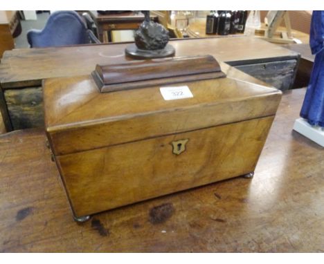 An early 19th century mahogany tea caddy, of sarcophagus form, enclosing a mixing well and twin compartments, fitted with lio
