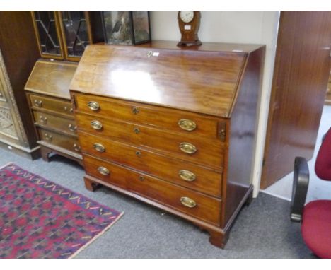 A George III mahogany slant-front bureau, the plain rectangular top above a slope opening to a fitted interior above four lon