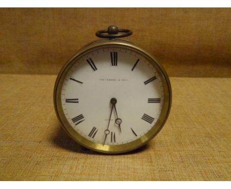 A late 19th century French brass drumhead desk clock, the white enamel dial with Roman numerals bearing retailer's name, Whit